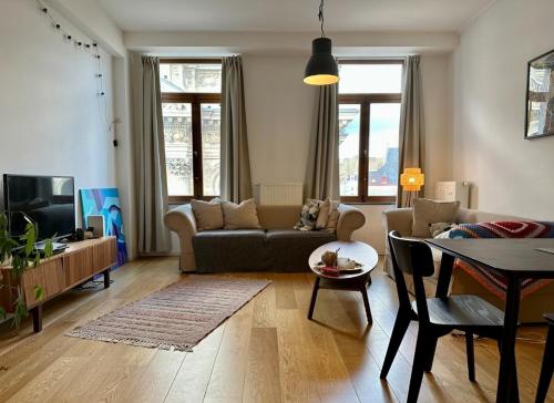 ein Wohnzimmer mit einem Sofa und einem Tisch in der Unterkunft Les Pieds a La Grande Place in Brüssel