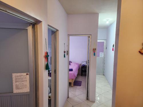 un pasillo que conduce a un dormitorio con una cama rosa en Casa Libélula, en Tehuacán