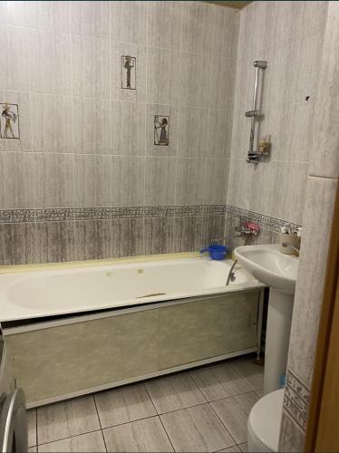 a bathroom with a bath tub and a sink at Квартира/Flat in Astana
