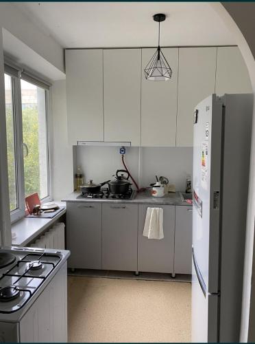 a kitchen with white cabinets and a refrigerator at Квартира/Flat in Astana
