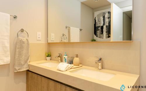 a bathroom with a sink and a mirror at Brand New Modern 2BR Retreat, Walk to Dubai Mall - Downtown Views ll in Dubai