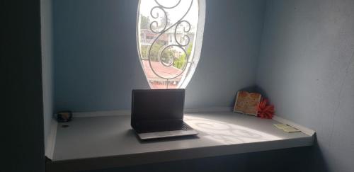 a laptop sitting on a table under a window at Lovely 2 bedroom vacation home with free parking. in Georgetown