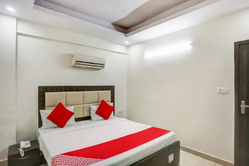 a bedroom with a bed with red pillows at OYO Flagship New Daffodil Inn in Ballabgarh