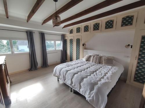 een slaapkamer met een groot bed in een kamer met ramen bij Chez Madeleine - Maison 11 pers. Parc arboré 3000M² in Lanobre