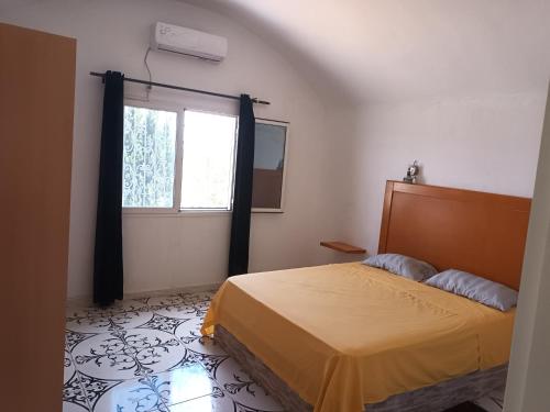 Schlafzimmer mit einem Bett und einem Fenster in der Unterkunft magnifique villa avec piscine in Dawwār al Frinine