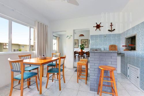 eine Küche und ein Esszimmer mit einem Tisch und Stühlen in der Unterkunft Casa da Mole Vista Cond Fechado Paraíso WIFI 250mb in Florianópolis
