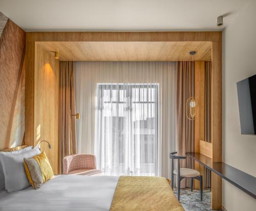 a hotel room with a bed and a window at Hotel Branco Timisoara in Timişoara