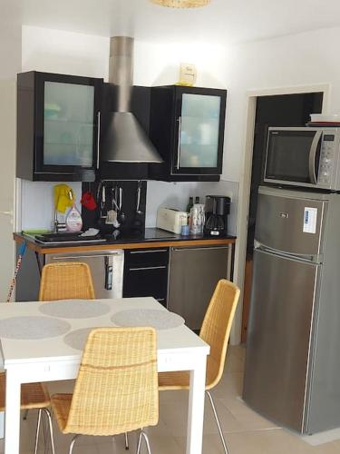 een keuken met een witte tafel en een koelkast bij Appartement Hardelot plage in Neufchâtel-Hardelot