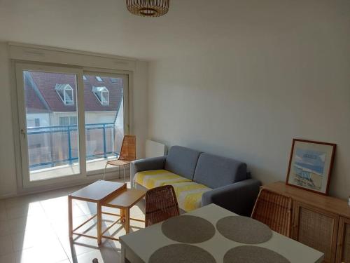 een woonkamer met een bank en een tafel bij Appartement Hardelot plage in Neufchâtel-Hardelot