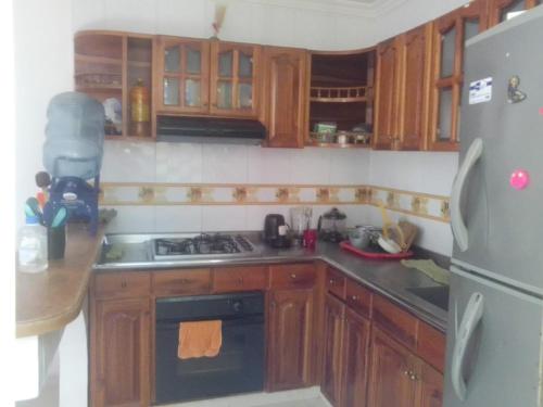 a kitchen with wooden cabinets and a stove and a refrigerator at Casa de Descanso in Ricaurte