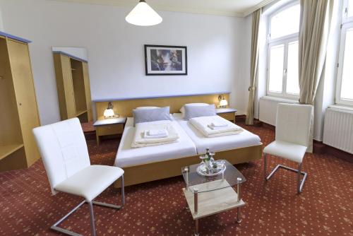 a hotel room with a bed and two chairs at Hotel Barbarossa in Reichshof 
