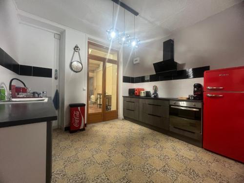 La cuisine est équipée d'un réfrigérateur rouge et d'un évier. dans l'établissement Charmante maison de ville, à Bléneau