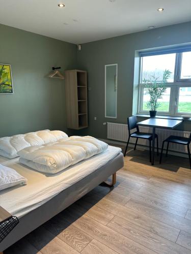 um quarto com uma cama e uma sala de jantar com uma mesa em Det gamle snedkeri em Ribe