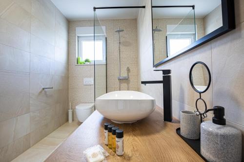 a bathroom with a large white tub and a mirror at Villa Corcovado II in Vodice