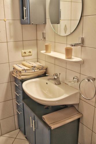 a bathroom with a sink and a mirror and towels at Ferienwohnung Karwendelblick in Mittenwald