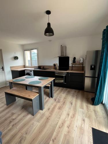 Il comprend une grande cuisine avec une table et une cuisine avec dans l'établissement Gîte des diligences, à Saint-Brès