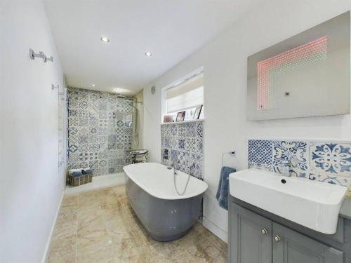 a bathroom with a large tub and a sink at Luxe Bungalow w/ Hot tub, pool table & more in Findon