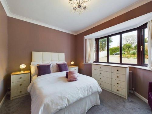 Un dormitorio con una gran cama blanca con ventana. en Luxe Bungalow w/ Hot tub, pool table & more, en Findon