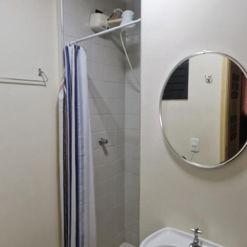 a bathroom with a mirror and a sink at Apartamento Praia das Toninhas in Ubatuba