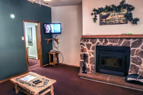 sala de estar con chimenea y TV en Timber Creek Chalets- 6 chalet en Estes Park