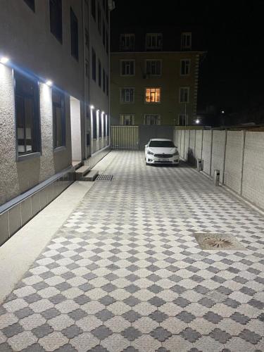 une voiture blanche garée sur un parking la nuit dans l'établissement Нарэл, à Bishkek