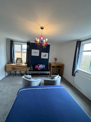 a room with a blue table and chairs and a chandelier at Stylish & Modern Central Studio Apartment Free parking in Southampton