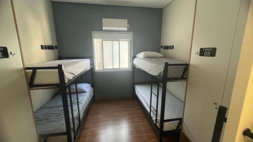 a small room with three bunk beds in it at Hostel Mirandopólis in Sao Paulo