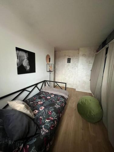 ein Schlafzimmer mit einem Bett und einem Zebrabild an der Wand in der Unterkunft Cosy appartement - Evry in Évry-les-Châteaux