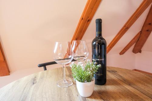 a bottle of wine and two wine glasses on a table at Apartman Maja in Jajce