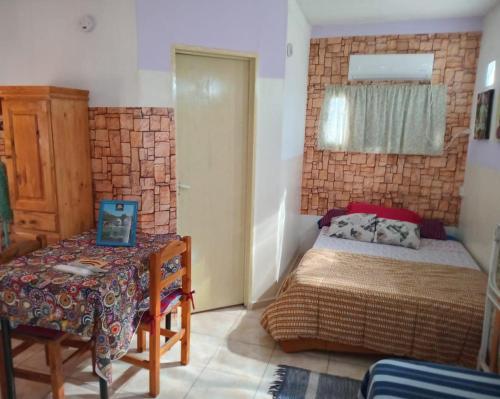 a small bedroom with a bed and a table at DORMI-con HIDROMASAJE- POSADA RUTA 22 totalmente EQUIPADO in Plottier
