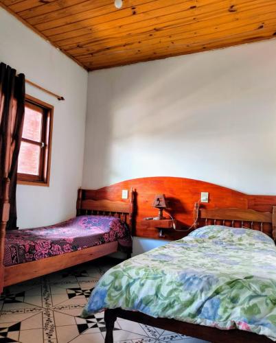 1 dormitorio con cama, ventana y techo de madera en Alojamiento Familiar Alternativo Daniel Oviedo en Puerto Iguazú