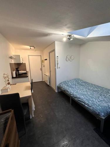 Cette chambre comprend un lit et une table. dans l'établissement Studio Centre Ville, à Bar-le-Duc
