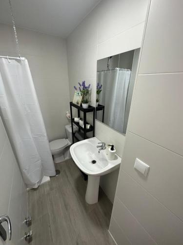 a white bathroom with a sink and a toilet at Alta Vista Punta Umbría in Punta Umbría