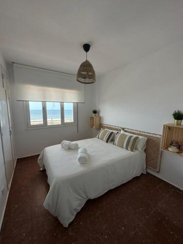 una camera da letto con un grande letto bianco con una finestra di Alta Vista Punta Umbría a Punta Umbría