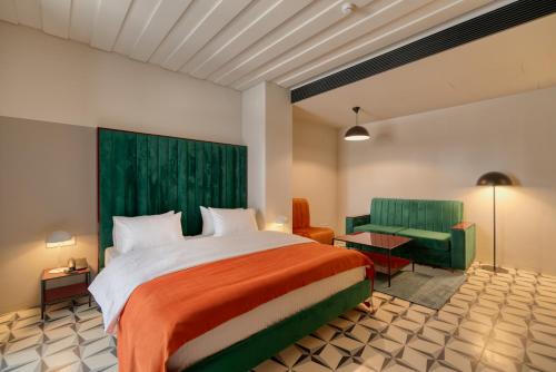 ein Schlafzimmer mit einem großen Bett und einer grünen Wand in der Unterkunft Manifest Restaurant and Hotel Gyumri in Gjumri