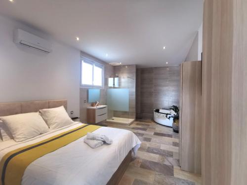 - une chambre avec un grand lit et une salle de bains dans l'établissement Entre mer et campagne, à Saint-Martin-de-Seignanx