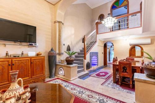 a large living room with a tv and a staircase at 16 Riads in Marrakesh