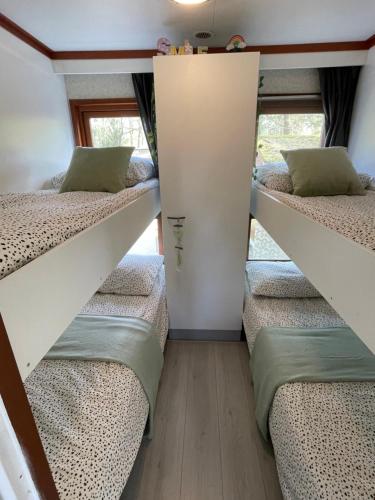 een kamer met 3 stapelbedden en een raam bij Ecolodge Over the Rainbow in Bocholt