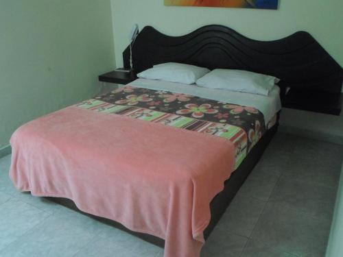 a bedroom with a bed with a pink blanket on it at Hotel Vermon Armenia in Armenia