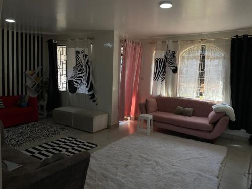 a living room with a couch and zebra heads on the wall at Villa Quartet Retreat in Nairobi