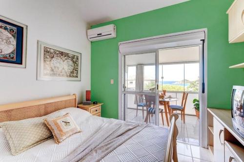 a bedroom with a bed and a green wall at Casa da Mole Praia Particular Churrasco wifi 250mb in Florianópolis