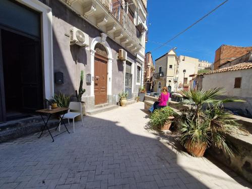 a woman sitting on the side of a building at Elvira Home in Catania
