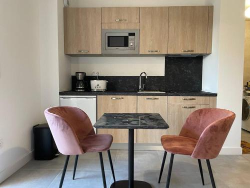 une petite cuisine avec une table et deux chaises dans l'établissement Superbe appartement neuf avec parking sur place, à Corte