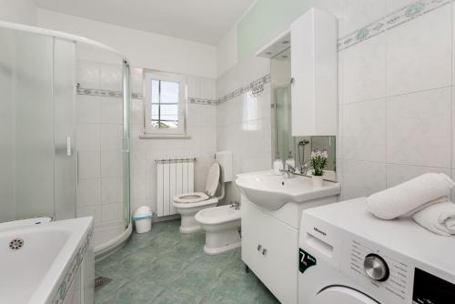 een witte badkamer met een toilet en een wastafel bij House Marko in Šumber