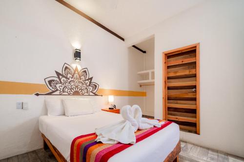 Una habitación de hotel con una cama con una toalla. en Hotel Axolotl en Puerto Escondido