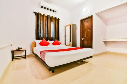 a bedroom with a large white bed with red pillows at OYO Flagship Ag Colony in Patna