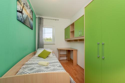 um quarto com uma cama com uma parede verde em House Marko em Šumber