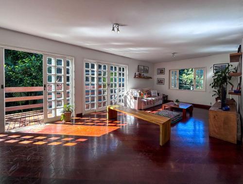 uma sala de estar com um sofá e um banco em Otima casa com lazer completo em Sao Conrado RJ no Rio de Janeiro