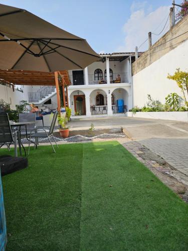 a patio with an umbrella in front of a house at Blue Moon Hostel in Antigua Guatemala