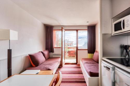 Ce petit appartement comprend un canapé et une table. dans l'établissement Résidence Quartier Falaise - maeva Home - Studio 5 personnes - Confort MAE-0504, à Avoriaz